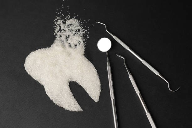 istock Dentist tools mirror and teeth made of sugar on a black background 2145850949