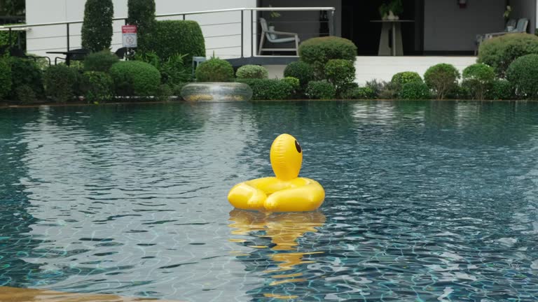 swimming pool with yellow and pink inflatable ring near the hotel