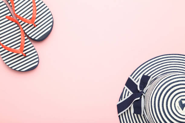 istock Summer straw hat with flip flops on pink background 2145920376