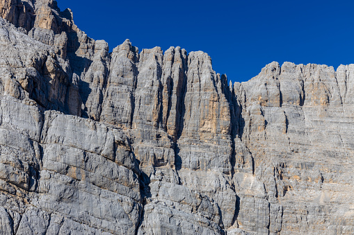 Dolomites mountains, Alpi Dolomiti beautiful scenic landscape in summer. Italian Alps mountain summits and rocky peaks above green valley alpine scene