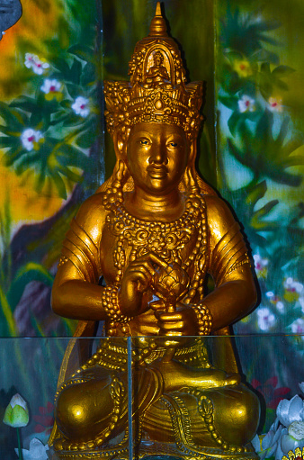 Close-Up Portrait View Of Golden Bodhisattva Statue On The Worship Altar Inside Room Of Buddhist Temple