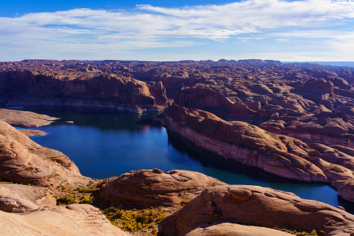 The Chains, Glen Canyon, Arizona. Red rocks, Lake Powell and cloudy sky background, copy space