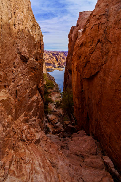 View Through Hole in the Rock Lake Powell - Steep gully that pioneer Mormon settlers came through on their way to discover a way to the Colorado River and through tricky steep, rugged canyon country.. High angle view looking dow to the clear blue waters of the lake.