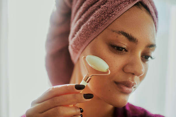 istock A woman using a facial roller during her daily skin care routine 2146317103