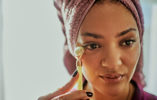 istock A woman using a facial roller during her daily skin care routine 2146317106