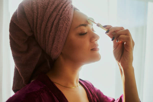 istock A woman using a facial roller during her daily skin care routine 2146317108