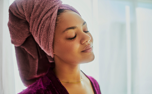 A shot of a woman enjoying a peaceful moment while doing her skincare routine. Stock photo
