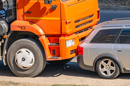 car accident between an orange truck and a passenger car. traffic accident. close-up