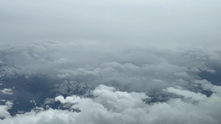 POV flying across a snowing winter sky. Overflying a snowed mountainous landscape shot from an airplane cockpit. Guadalajara, Spain. 4K