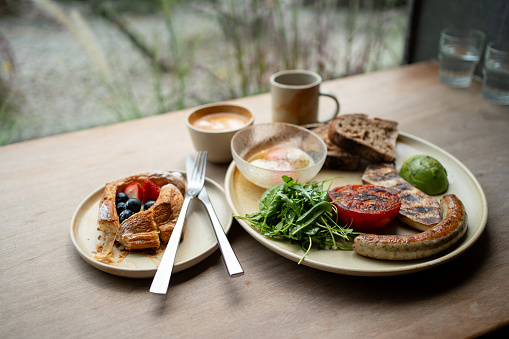 A big breakfast set with Americano and hot latte, served on a wooden table background