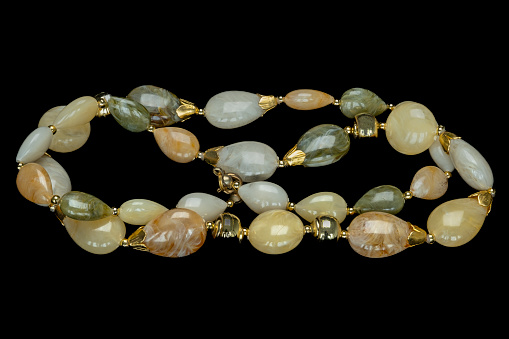 Costume jewellery necklace made up from different gem stones and coupled together with gold clasps and gold coloured pearls.