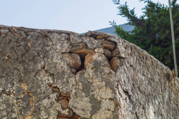 istock Destruction of wall under influence of natural factors, such as variable humidity, temperature, sunlight, aging and deterioration of structural materials, splitting into individual component parts 2146535463