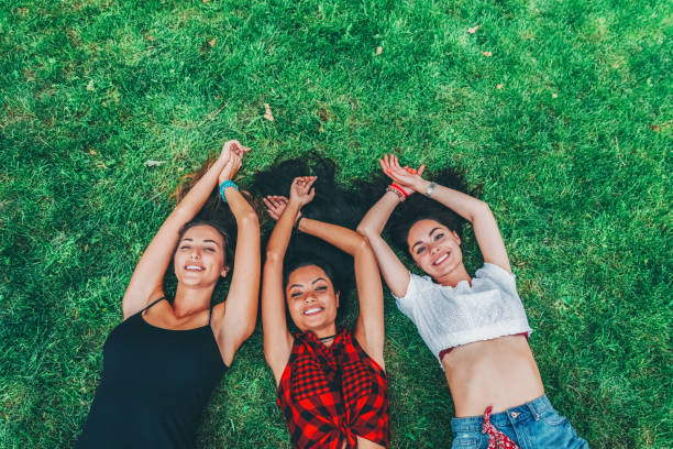 Happy friends lying down on the grass