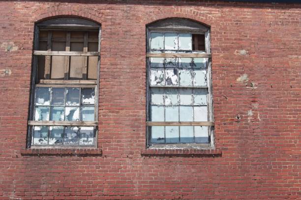 istock Brick wall with shattered windows in an abandoned building 2146547455