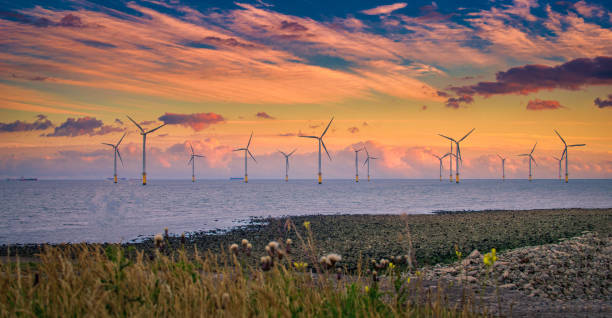 istock Offshore Wind Turbine in a Windfarm under construction off the England Coast at sunset 2146583849
