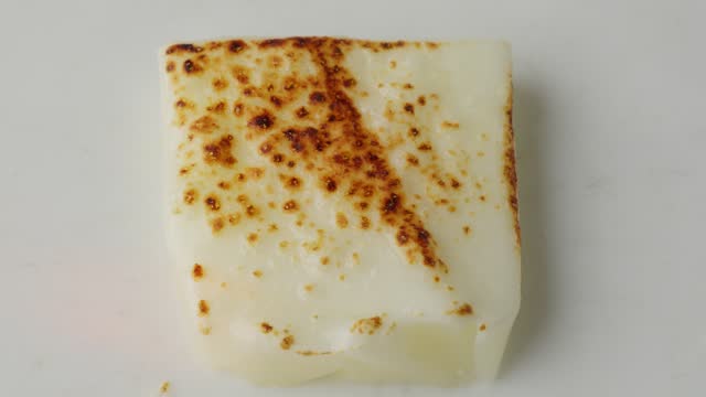 Mozzarella Cheese Slice Flake Up and Burn By Blowtorch Flame, Close Up Top Down