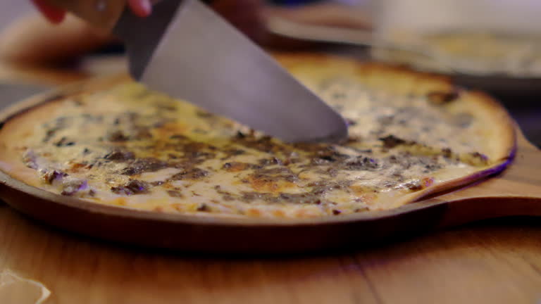 4K footage Front view Close-up Slice of pizza is cut in half and placed on a wooden table.