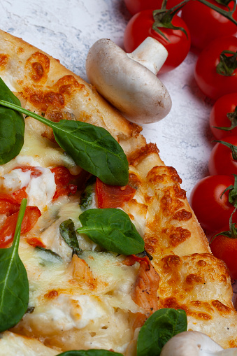 Pizza with spinach, cherry tomatoes and gorgonzola cheese on a light background, top view, free space for text