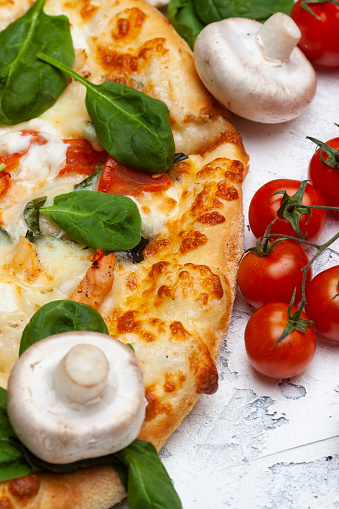 Pizza with spinach, cherry tomatoes and gorgonzola cheese on a light background, top view, free space for text