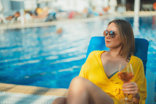 istock Pretty woman with wine relaxing by the pool. 2146633297