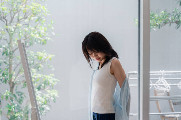 istock Young woman changing clothes at home 2146678585