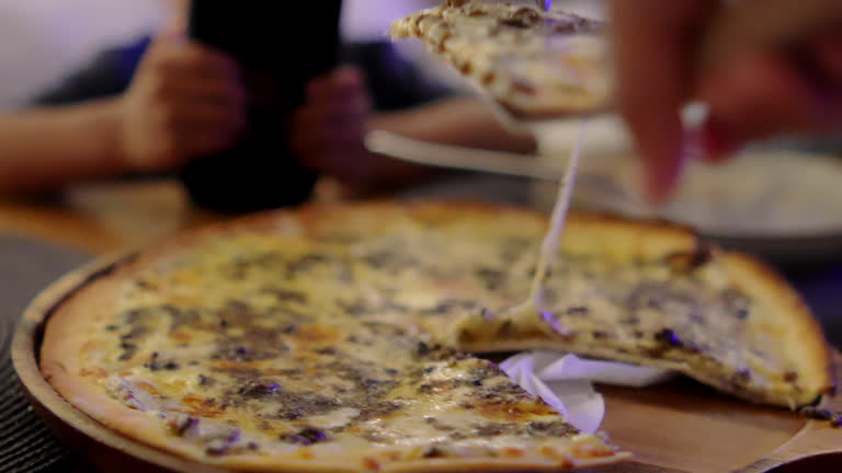 4K footage Front view Close-up Slice of pizza is cut in half and placed on a wooden table.