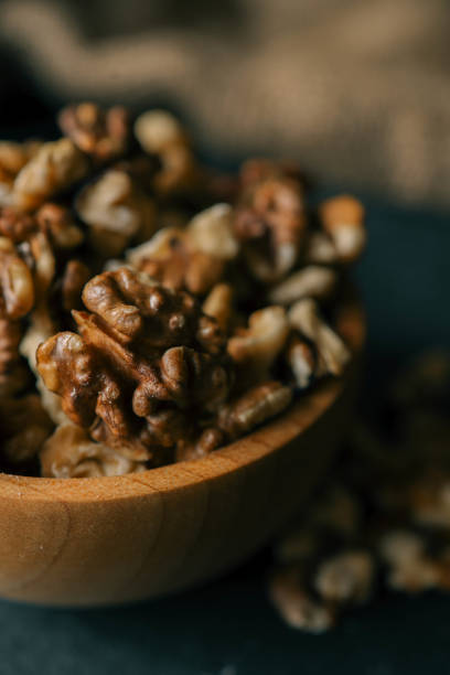 istock Walnuts in a wooden plate on a dark background 2146692185