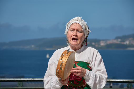 Vigo, Pontevedra, Spain; April 7, 2024; a tambourine singer sings with the Vigo estuary in the background during the Reconquest of Vigo festival