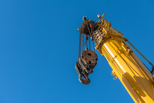 Yellow crane with raised telescopic arm ready to go into action.