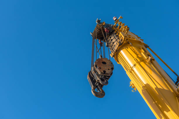 Yellow force Yellow crane with raised telescopic arm ready to go into action. hook equipment stock pictures, royalty-free photos & images