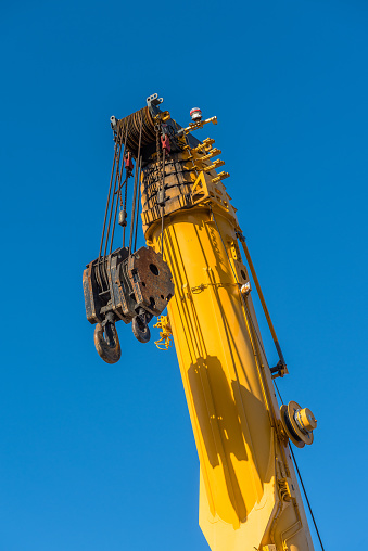 Yellow crane with raised telescopic arm ready to go into action.