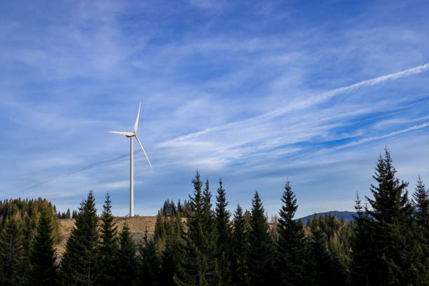 istock One white windmill on a mountain in the woods against a blue sky with clouds. 2146738162