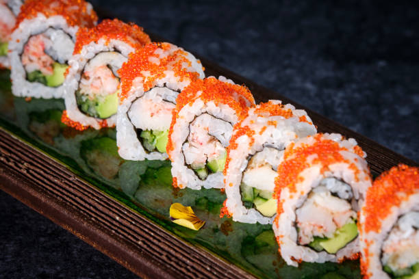 istock Delicious sushi rolls reflecting in Japanese wooden dishware 2146745646