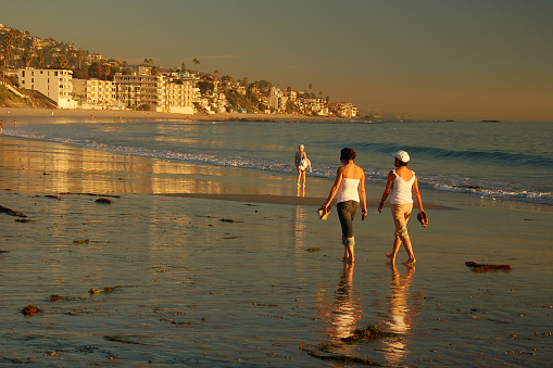 Laguna Beach, CA, USA November 6 Two adult women friends walk along the coastline of the Pacific Ocean at Laguna Beach, California on a relaxing vacation day