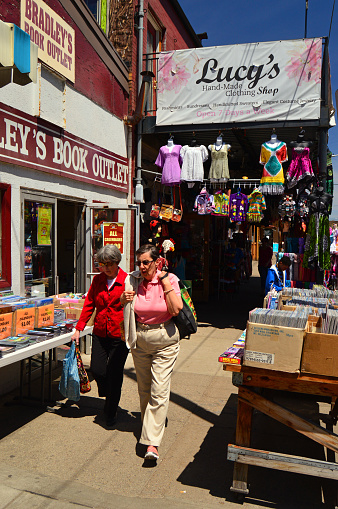 Pittsburgh, PA, USA May 6 Two adults shop at the used books and clothes stores and sidewalk sales in the Strip business district of Pittsburgh, Pennsylvania