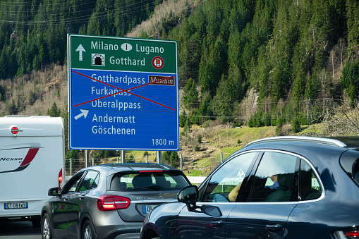 Goschenen, Switzerland - April 6, 2024: Vehicles standing in a queue in front of the Gotthard motorway tunnel. Flixbus bus transport company.