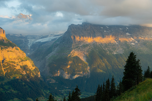Scenic tranquil view of awe-inspiring sunset over Swiss Alps in summer visible from hiking trail