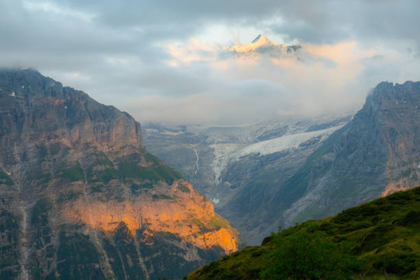 Scenic tranquil view of awe-inspiring sunset over Swiss Alps in summer visible from hiking trail