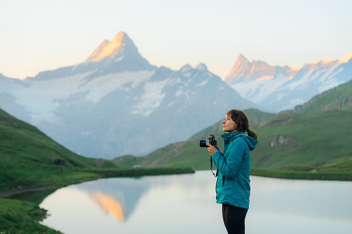 Woman with camera near Bachalpsee lake in Swiss Alps