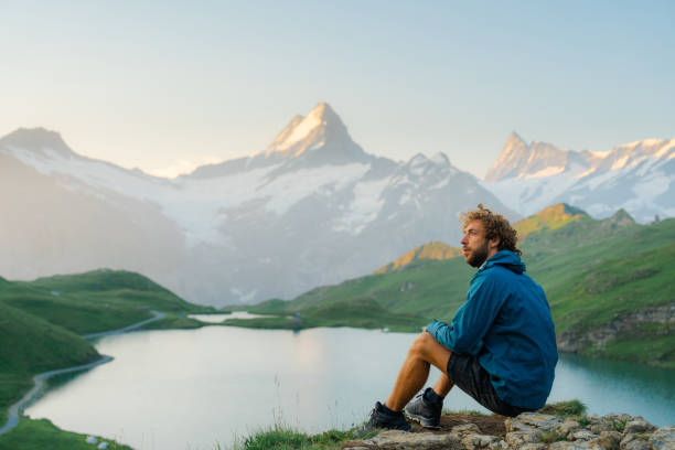 istock Man looking at Bachalpsee in Swiss Alps in the morning 2146893708