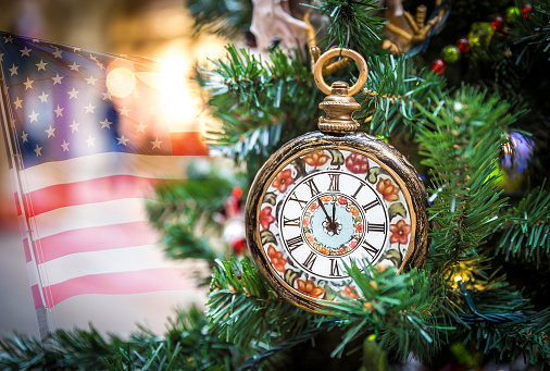 Christmas tree decoration with clocks showing five minutes left to new year with usa flag on a background