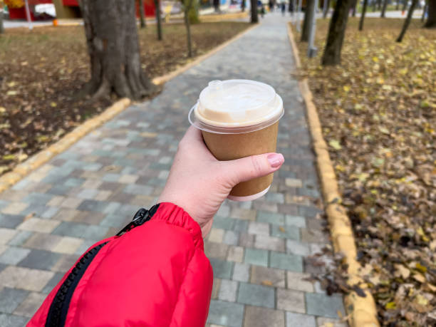 istock Hand holding coffee cup on autumn park background 2146926118