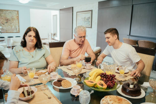 istock Father and son looking at smartphone at breakfast - Multigenerational family 2147025085