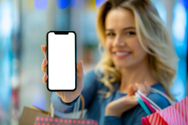 istock Shopping Happiness: Woman Smiles Holding Smartphone Screen Towards Camera 2147035850