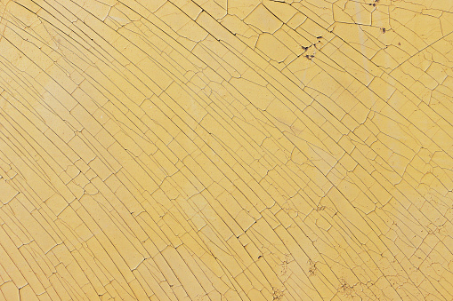 A pattern with the effect of dried and aged yellow paint cracks.