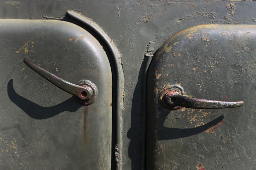 Old, abandoned armored vehicles. Doors with handles close-up.