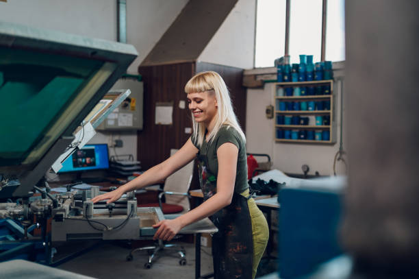 istock Print shop worker mounting silkscreen printing plate on machine. 2147087615