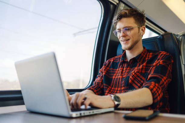 istock A traveler in train near window is typing on a laptop while commuting. 2147088151