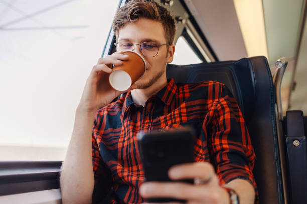 istock A traveler is drinking coffee to go and using cellphone in train. 2147088158