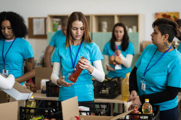istock Female aid workers packing food together 2147100039